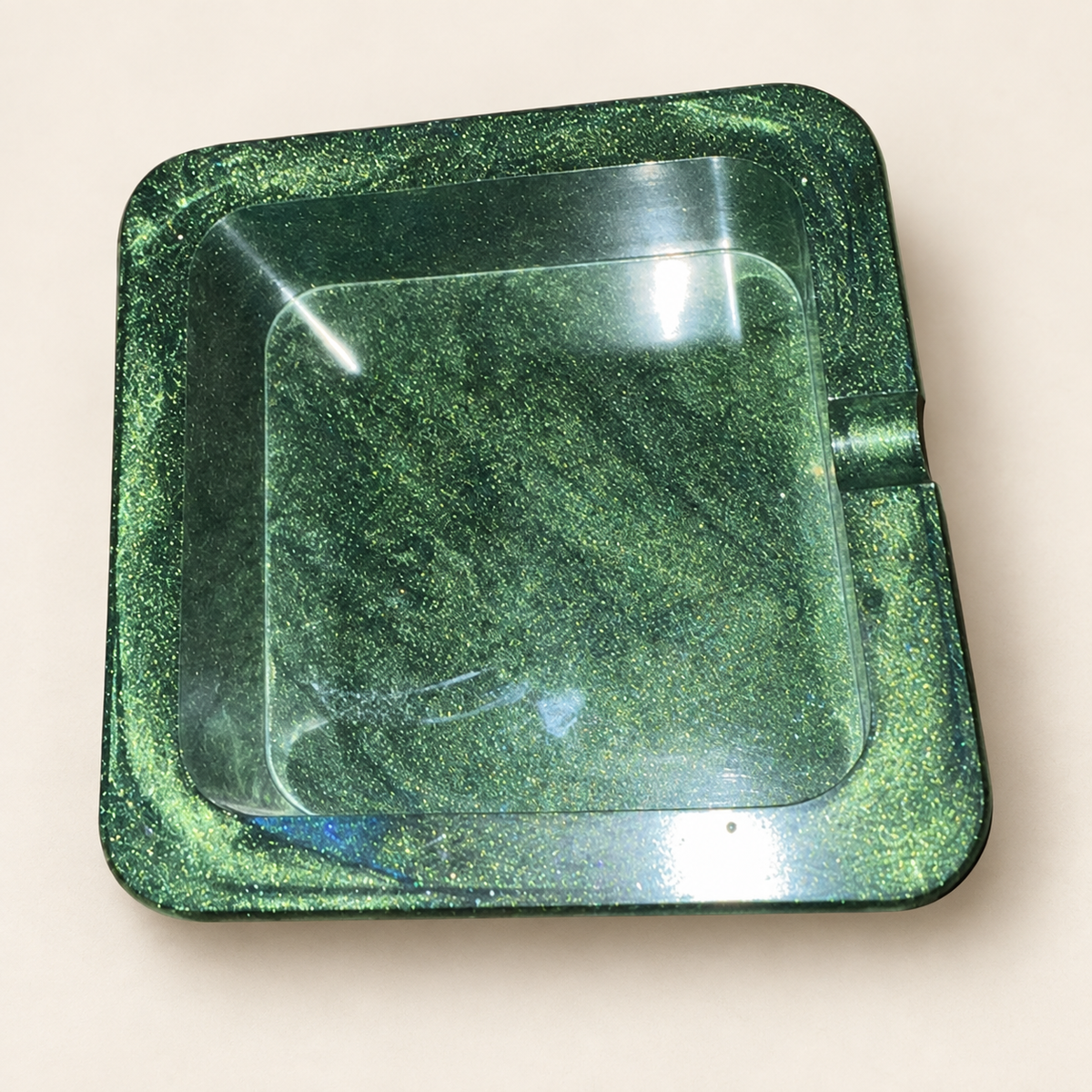 green shimmer small square resin ashtray with one notch on cream background